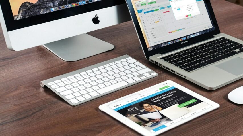 tu página web, A sleek office desk setup featuring Apple devices: iMac, MacBook, and iPad.