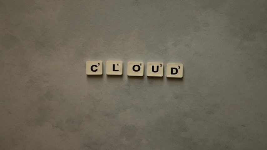 40% en costos operativos de TI, Scrabble tiles arranged to spell 'cloud' on a neutral textured backdrop, creative concept image.