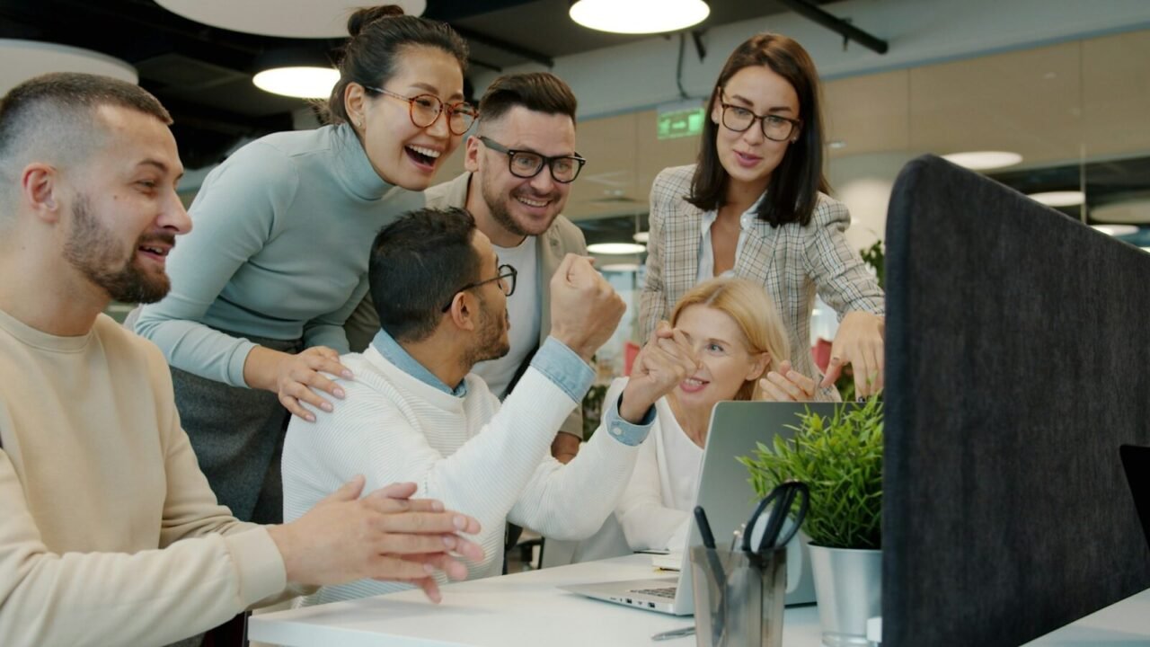 Capacitación en habilidades blandas, Diverse team celebrating success at office desk