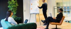 transformación organizacional, A group of professionals engaged in a collaborative meeting in a bright, modern office environment.