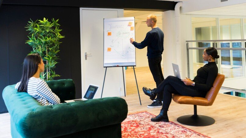 transformación organizacional, A group of professionals engaged in a collaborative meeting in a bright, modern office environment.