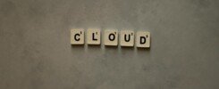 40% en costos operativos de TI, Scrabble tiles arranged to spell 'cloud' on a neutral textured backdrop, creative concept image.