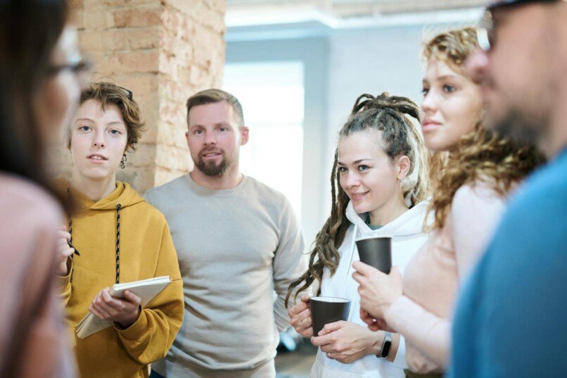 comunicación que impulsa, Diverse team engaged in a collaborative meeting in a contemporary office setting with natural lighting.