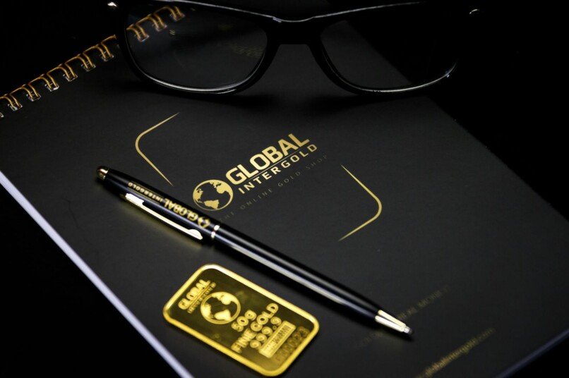 transformación empresarial exitosa, An elegant setup with a notebook, pen, and gold bar, embodying luxury and style.