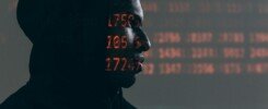 cuánto cuesta un ataque cibernético, Side profile of a man in a hoodie, surrounded by red code, depicting cybersecurity theme.