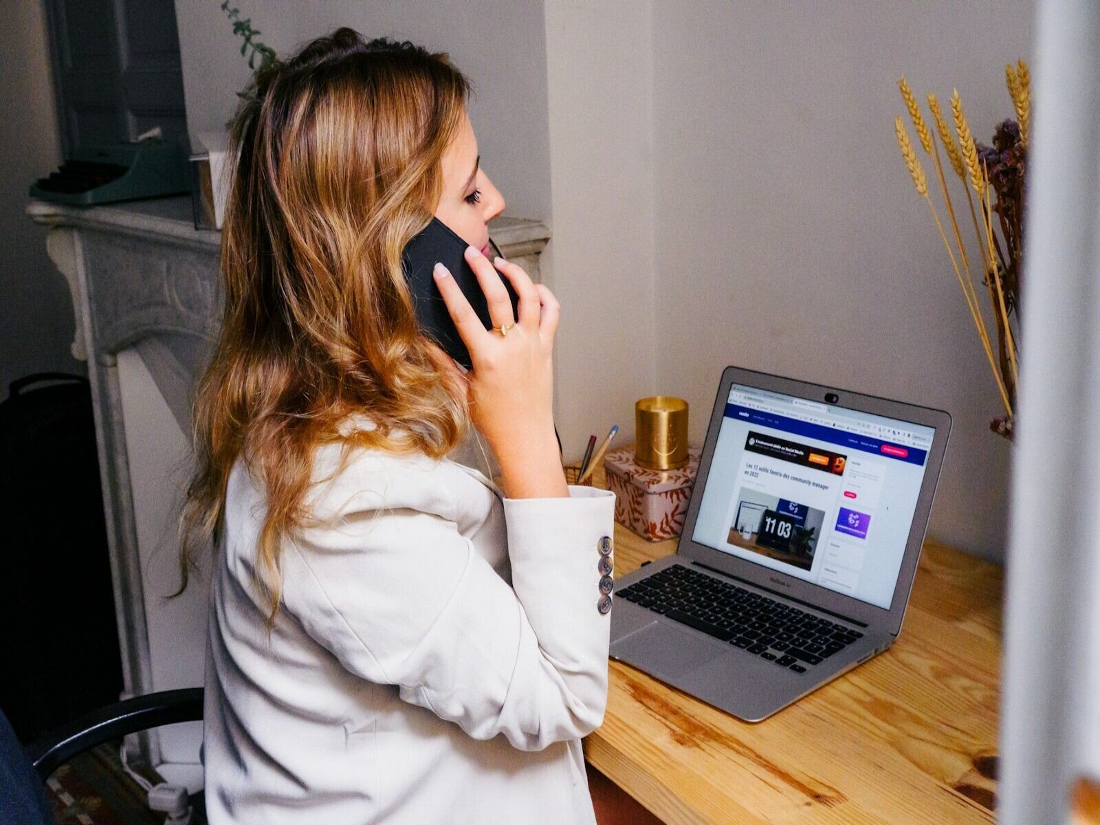 seguimiento comercial efectivo, a woman sitting at a desk with a laptop and a phone