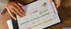 indicadores de gestión comercial, Top view of hands holding a financial report with colorful graphs and charts, ideal for business presentations.