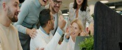 Capacitación en habilidades blandas, Diverse team celebrating success at office desk