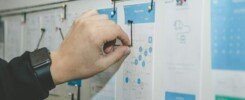 planeación estratégica empresarial, person working on blue and white paper on board
